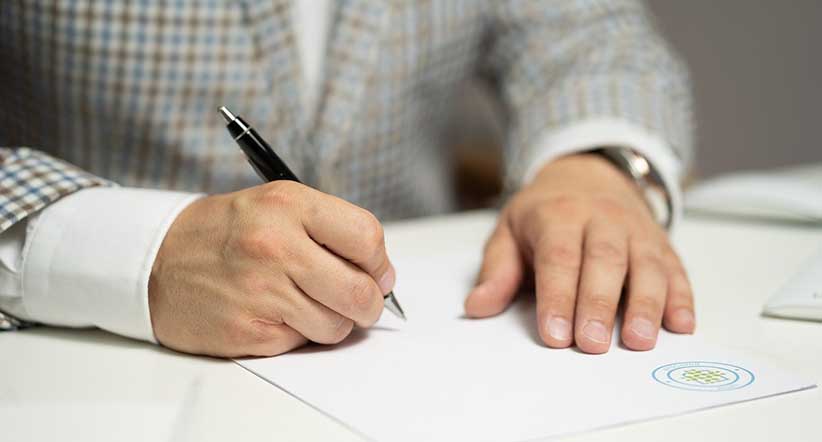 A man signing a contract when renovating a home from afar.